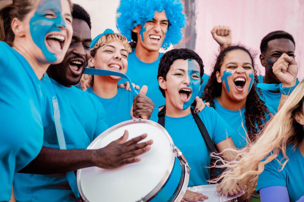Multiracial blue football fans celebrating in crowd supporting their team at world champion event